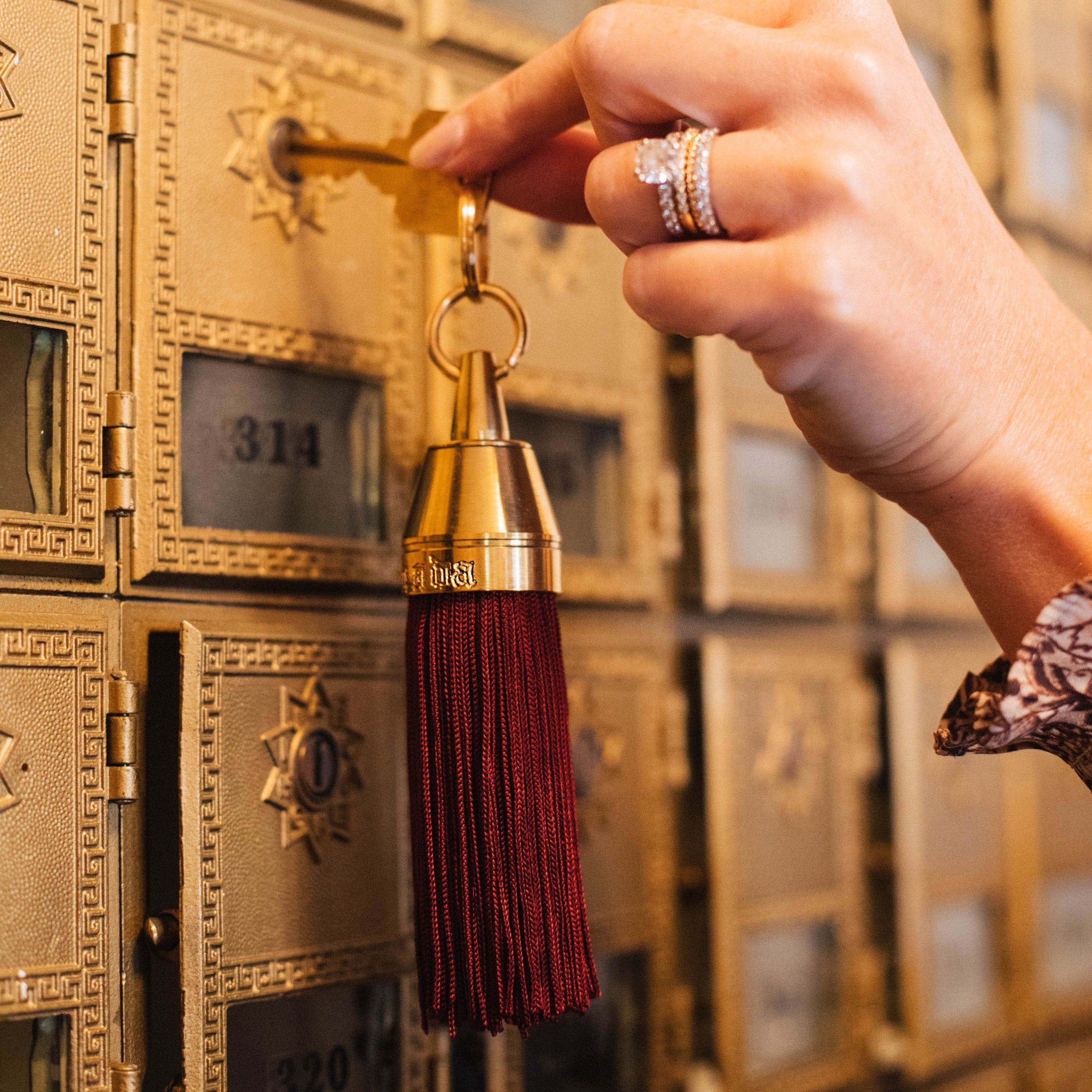 Granada Hotel Signature Tassel Keychain solid brass keychains burgundy silk tassel Nomada Signature for Granada San Luis Obispo by Nomada Deco